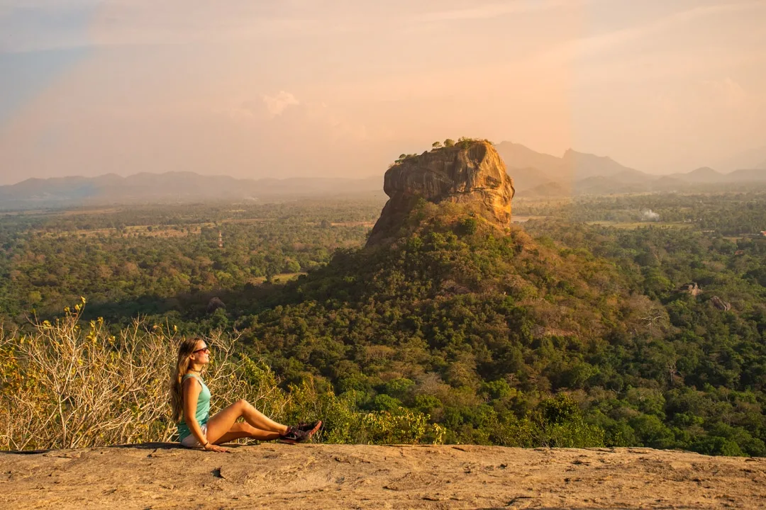 Tourist Witness the beauty of nature while sitting on a rock which is around nature resort Sigiri Vananthara.