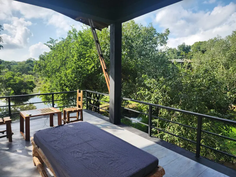 Outdoor patio with seating and a view of a lush green landscape at Sigiri Vananthara, a Nature Resort in Sigiriya.