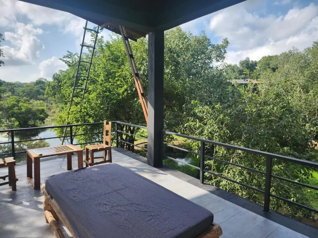 Outdoor patio with seating and a view of a lush green landscape at Sigiri Vananthara, a Nature Resort in Sigiriya.
